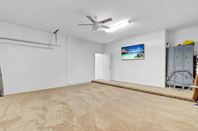 garage featuring ceiling fan and concrete block wall