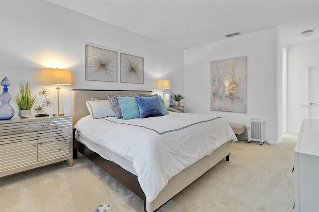 bedroom with light colored carpet, visible vents, and radiator heating unit