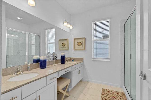 bathroom featuring marble finish floor, a sink, and a shower stall