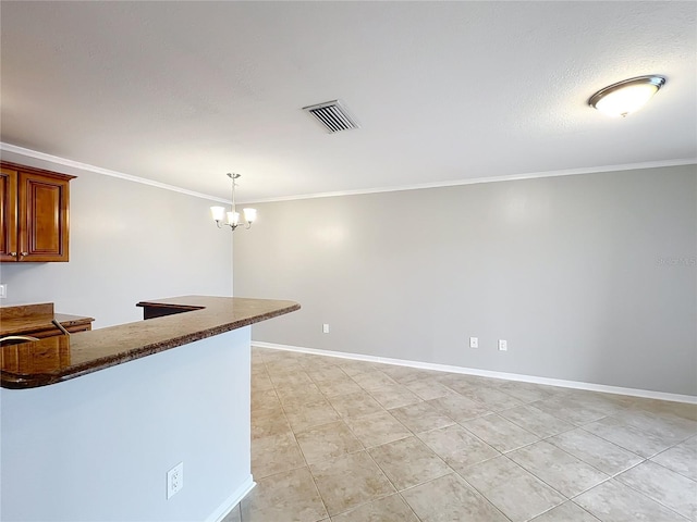 kitchen with baseboards, visible vents, ornamental molding, and an inviting chandelier