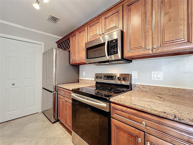 kitchen with light stone counters, brown cabinets, stainless steel appliances, visible vents, and ornamental molding
