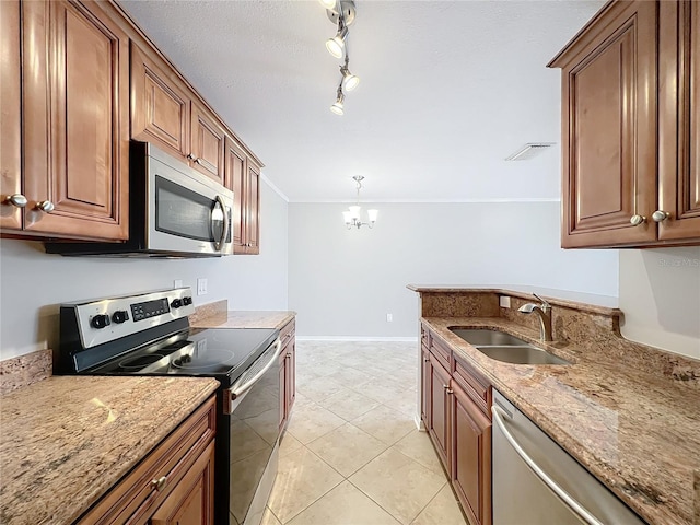 kitchen with a sink, stainless steel appliances, light stone countertops, and a chandelier