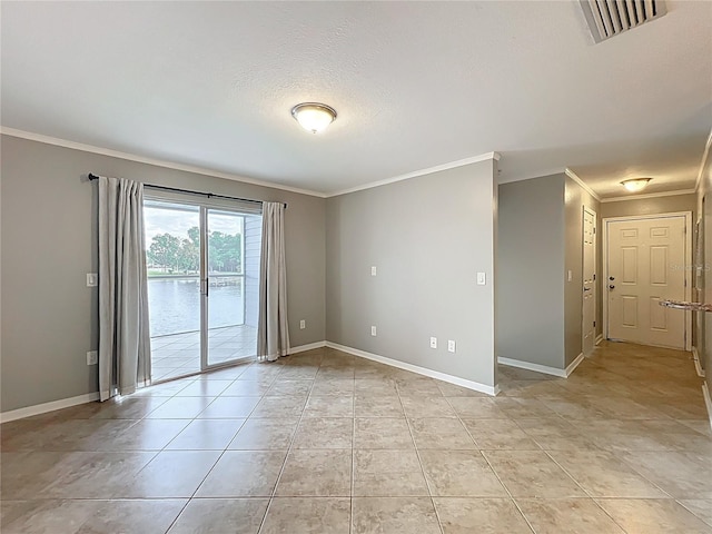 empty room featuring light tile patterned flooring, ornamental molding, baseboards, and visible vents