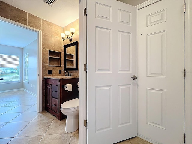bathroom featuring tile walls, visible vents, toilet, tile patterned floors, and vanity