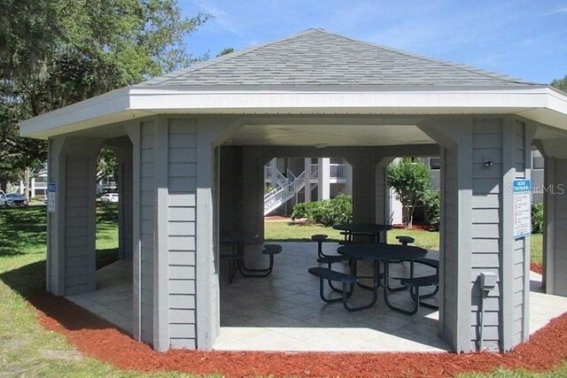 surrounding community with a lawn and a patio area