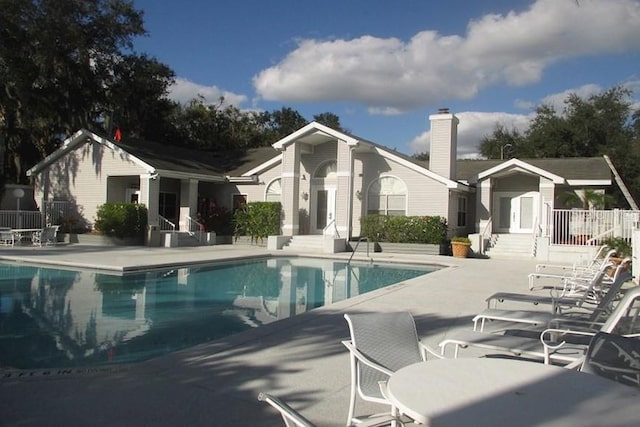 pool with a patio, fence, and entry steps