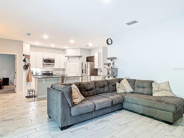 living area with visible vents and recessed lighting