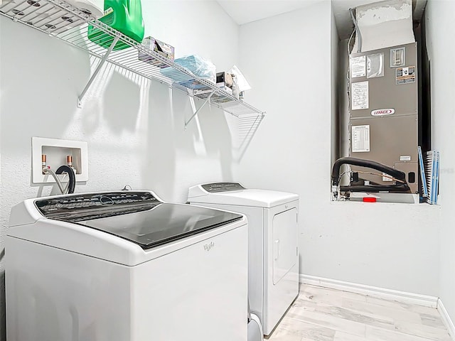 laundry area featuring washing machine and dryer, heating unit, laundry area, and baseboards