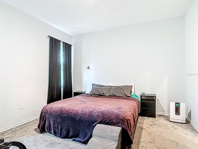 bedroom featuring carpet and baseboards