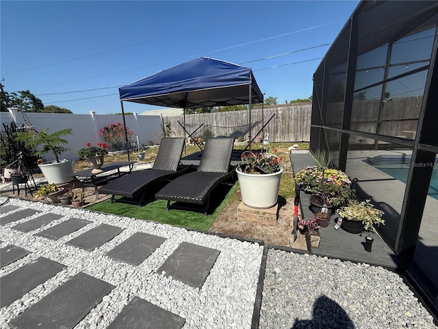 view of patio / terrace with a fenced backyard, a fenced in pool, and glass enclosure