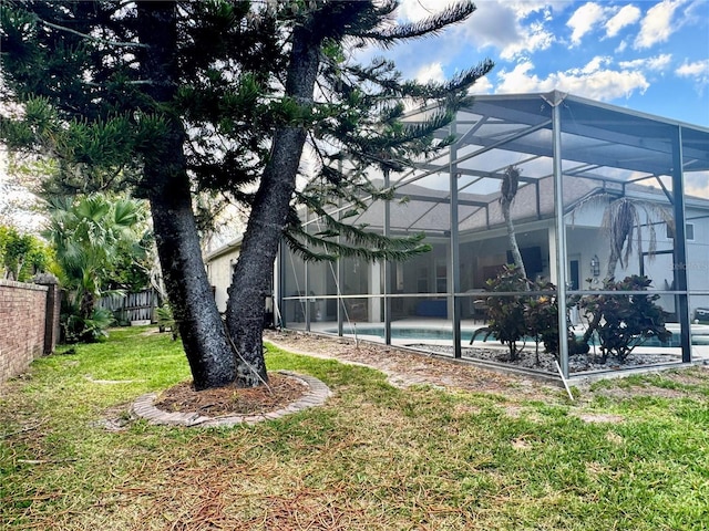 view of yard with a fenced in pool, a lanai, and fence