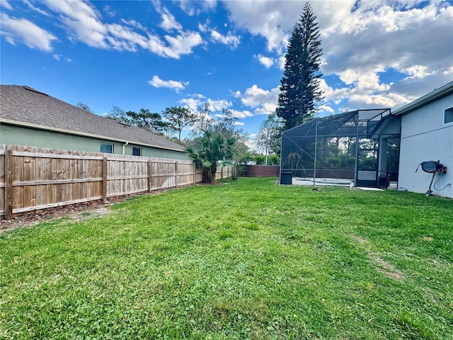 view of yard with a lanai and a fenced backyard