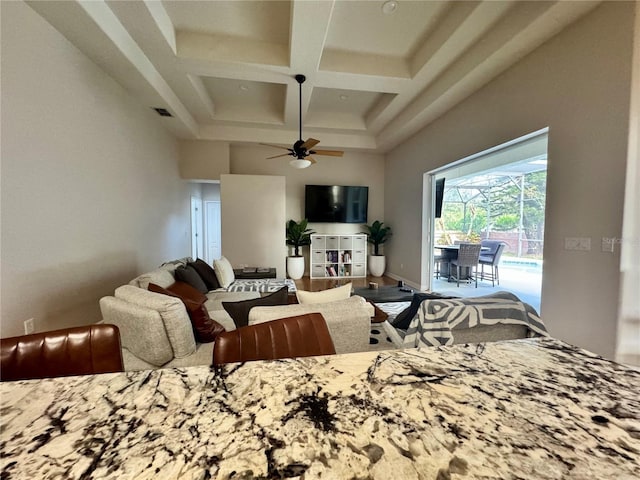 living room with visible vents, coffered ceiling, beamed ceiling, a ceiling fan, and a high ceiling