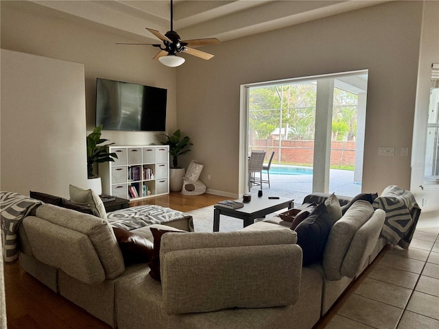 tiled living room featuring ceiling fan and baseboards