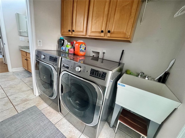 laundry room with washing machine and dryer, baseboards, cabinet space, and light tile patterned flooring