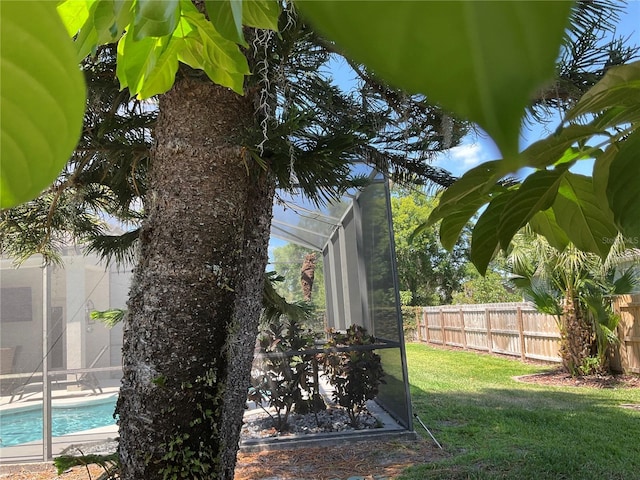 view of yard featuring glass enclosure, a fenced in pool, and fence