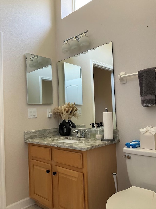bathroom featuring a high ceiling, toilet, and vanity