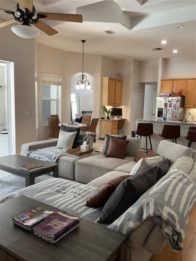 living room featuring recessed lighting, visible vents, and ceiling fan with notable chandelier