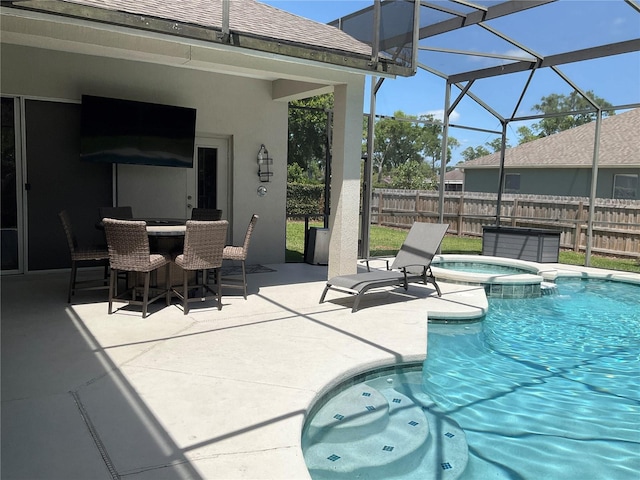 view of pool with fence, a patio area, glass enclosure, and a pool with connected hot tub