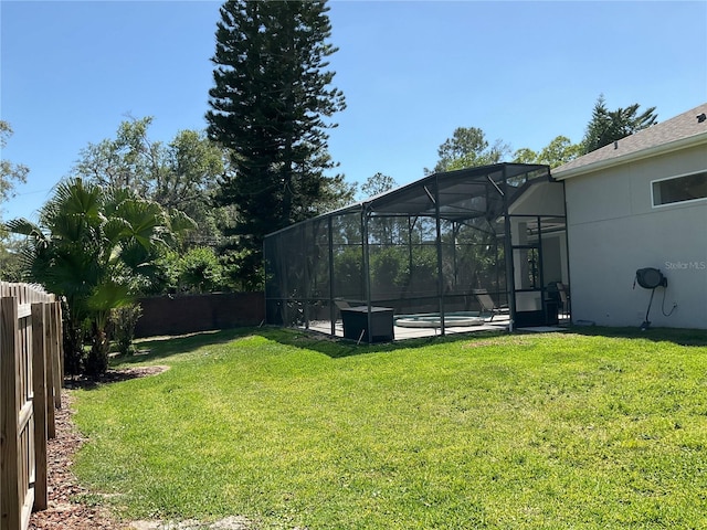 view of yard with a fenced backyard, an outdoor pool, and glass enclosure