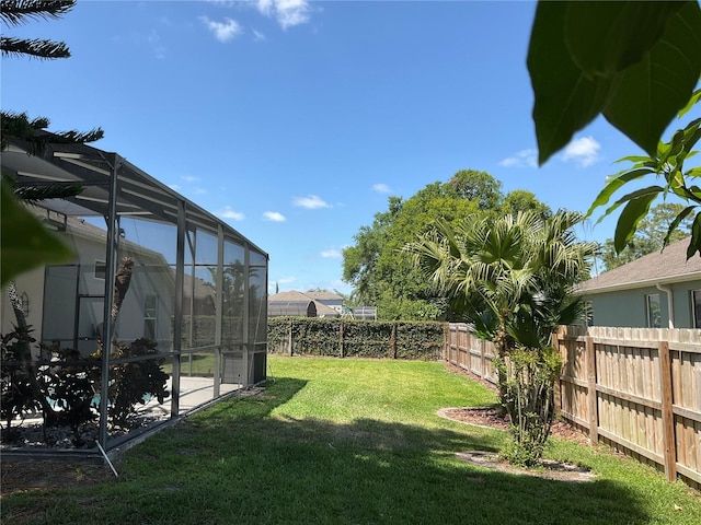 view of yard featuring a patio area, a lanai, and a fenced backyard