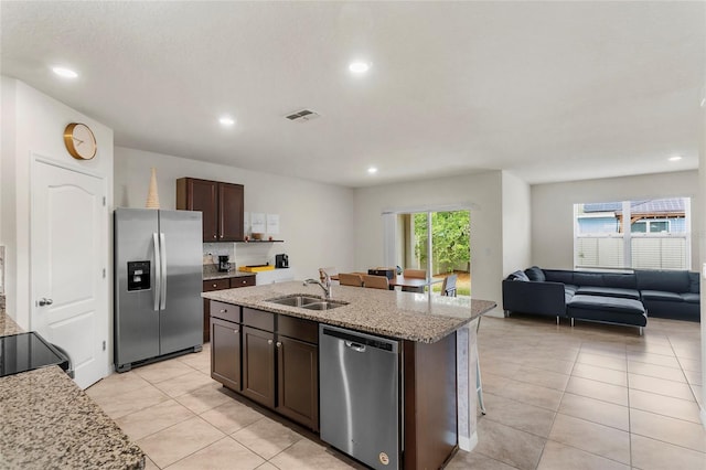 9005 Tuscan Cypress St, Kissimmee, FL 34747 - kitchen featuring appliances with stainless steel finishes, dark brown cabinets, recessed lighting, light tile patterned floors, and open floor plan