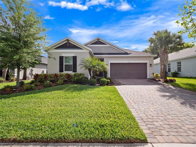 1151 Lakeside Estates Dr, Apopka, FL 32703 - single story home with a front yard, decorative driveway, stucco siding, and an attached garage