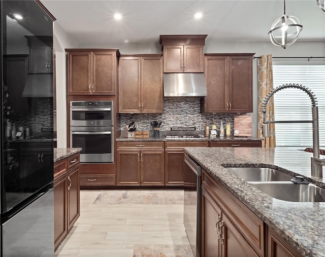 1151 Lakeside Estates Dr, Apopka, FL 32703 - kitchen with decorative backsplash, dark stone counters, appliances with stainless steel finishes, a sink, and ventilation hood