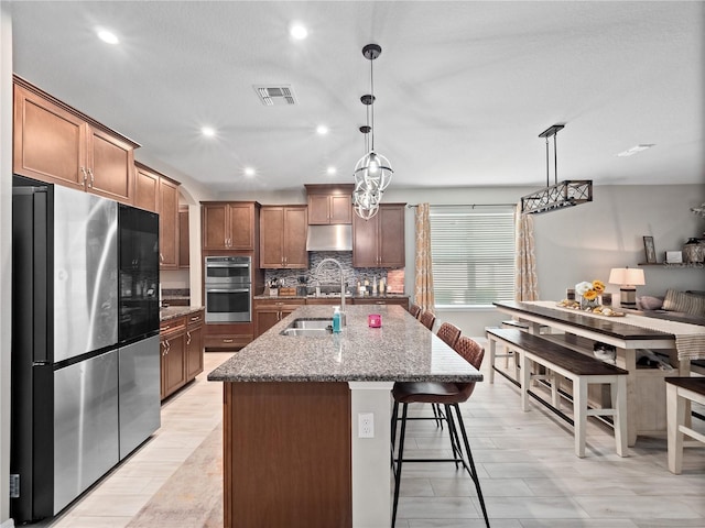 1151 Lakeside Estates Dr, Apopka, FL 32703 - kitchen featuring decorative backsplash, visible vents, a kitchen bar, stainless steel appliances, and a sink