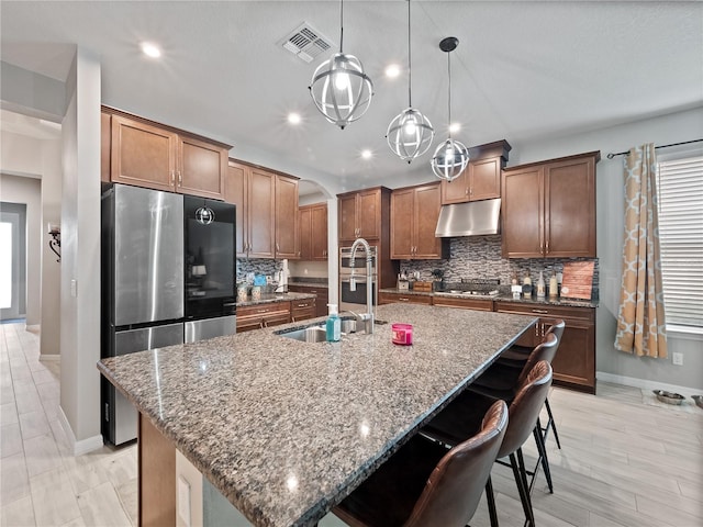 1151 Lakeside Estates Dr, Apopka, FL 32703 - kitchen featuring visible vents, tasteful backsplash, appliances with stainless steel finishes, under cabinet range hood, and an island with sink
