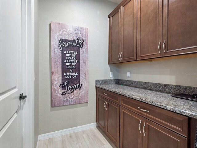 1151 Lakeside Estates Dr, Apopka, FL 32703 - kitchen with dark brown cabinets, baseboards, and dark stone counters