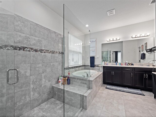 1151 Lakeside Estates Dr, Apopka, FL 32703 - full bathroom featuring a bath, a shower stall, double vanity, a sink, and tile patterned flooring
