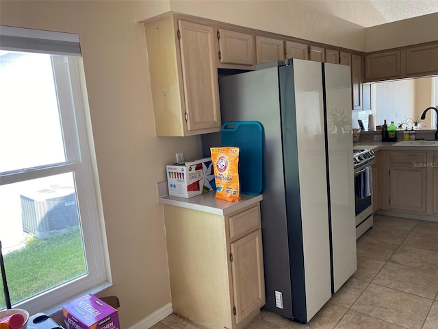 1210 Etchfield Cir, Brandon, FL 33511 - kitchen featuring stainless steel electric range, freestanding refrigerator, light countertops, light tile patterned flooring, and light brown cabinetry