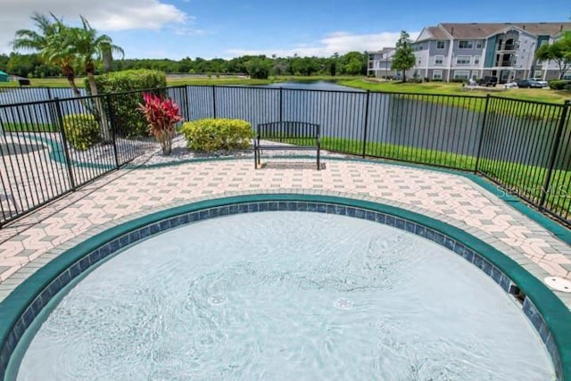 view of pool with fence and a water view