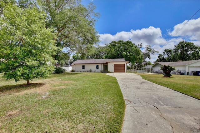 ranch-style home featuring an attached garage, driveway, and a front yard