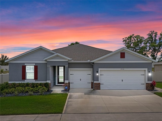 ranch-style home with stone siding, concrete driveway, stucco siding, fence, and an attached garage