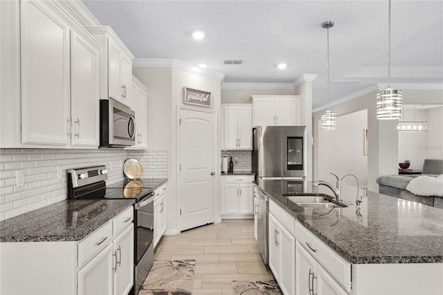 kitchen with a center island with sink, a sink, white cabinetry, and appliances with stainless steel finishes