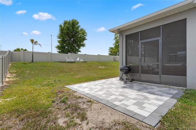 view of yard featuring a sunroom, a fenced backyard, and a patio area