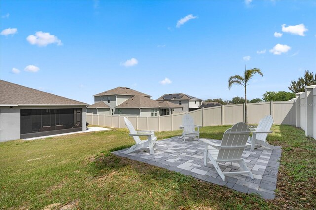 view of yard with a sunroom, a fenced backyard, and a patio area