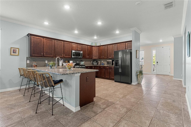 kitchen featuring a peninsula, crown molding, visible vents, and stainless steel appliances