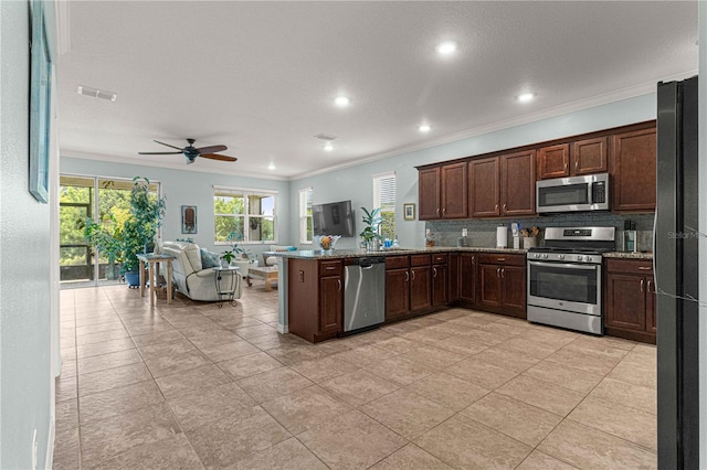 kitchen with visible vents, ornamental molding, open floor plan, stainless steel appliances, and backsplash