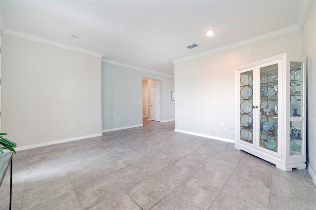 unfurnished room with visible vents, baseboards, and crown molding