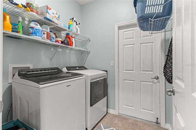 washroom with laundry area, baseboards, and washing machine and dryer