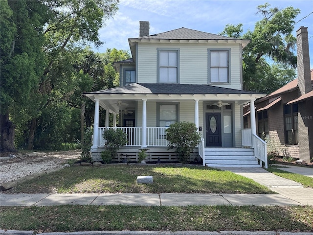 view of front of house with a chimney, roof with shingles, a ceiling fan, and covered porch