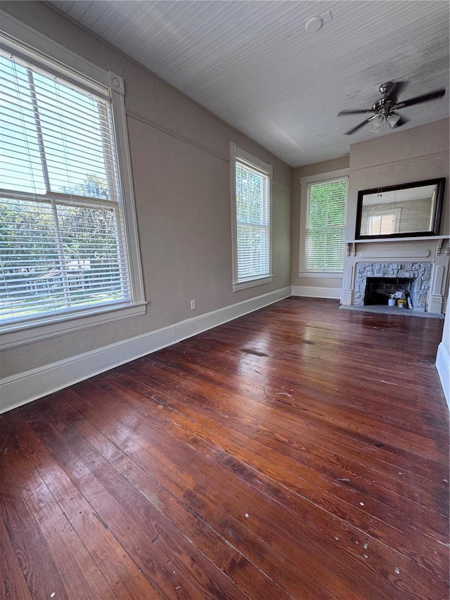 unfurnished living room featuring a fireplace, hardwood / wood-style floors, baseboards, and ceiling fan