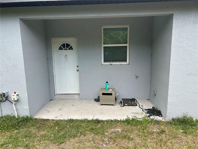 view of exterior entry featuring stucco siding