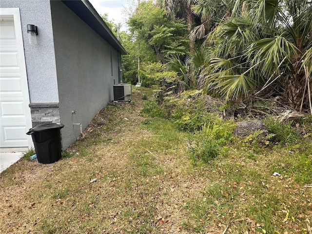 view of yard with central air condition unit and a garage