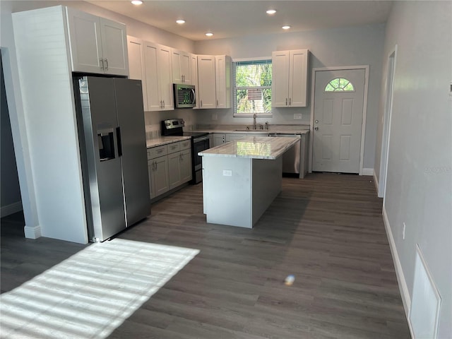 kitchen featuring a kitchen island, recessed lighting, appliances with stainless steel finishes, a sink, and baseboards