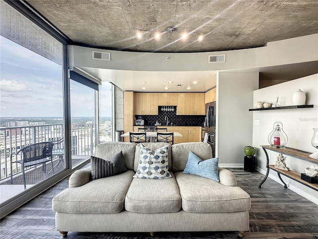 living area with dark wood finished floors, baseboards, and visible vents