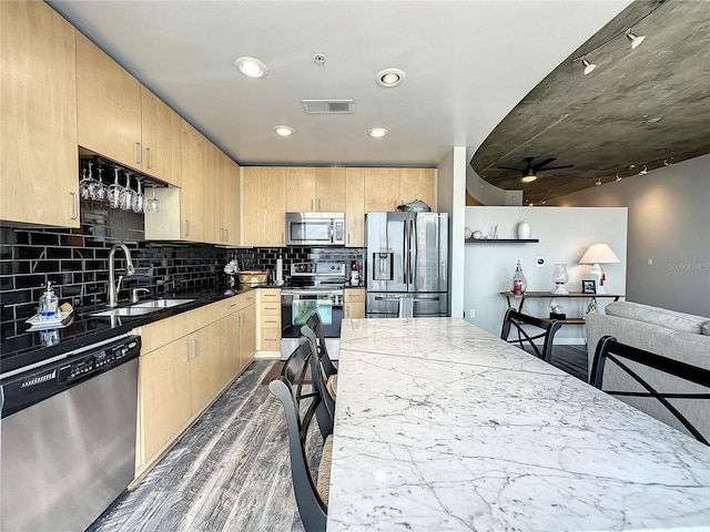 kitchen featuring visible vents, stainless steel appliances, dark wood finished floors, light brown cabinets, and a sink